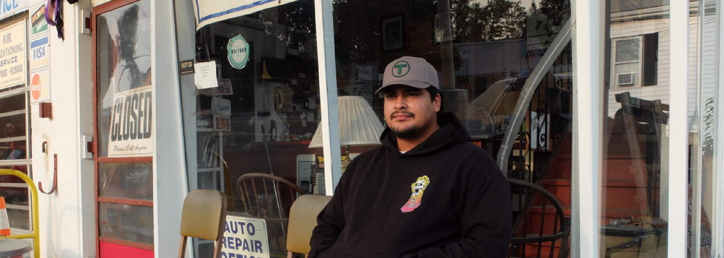 man wearing grey baseball cap with green Boston MBTA T puff embroidered logo