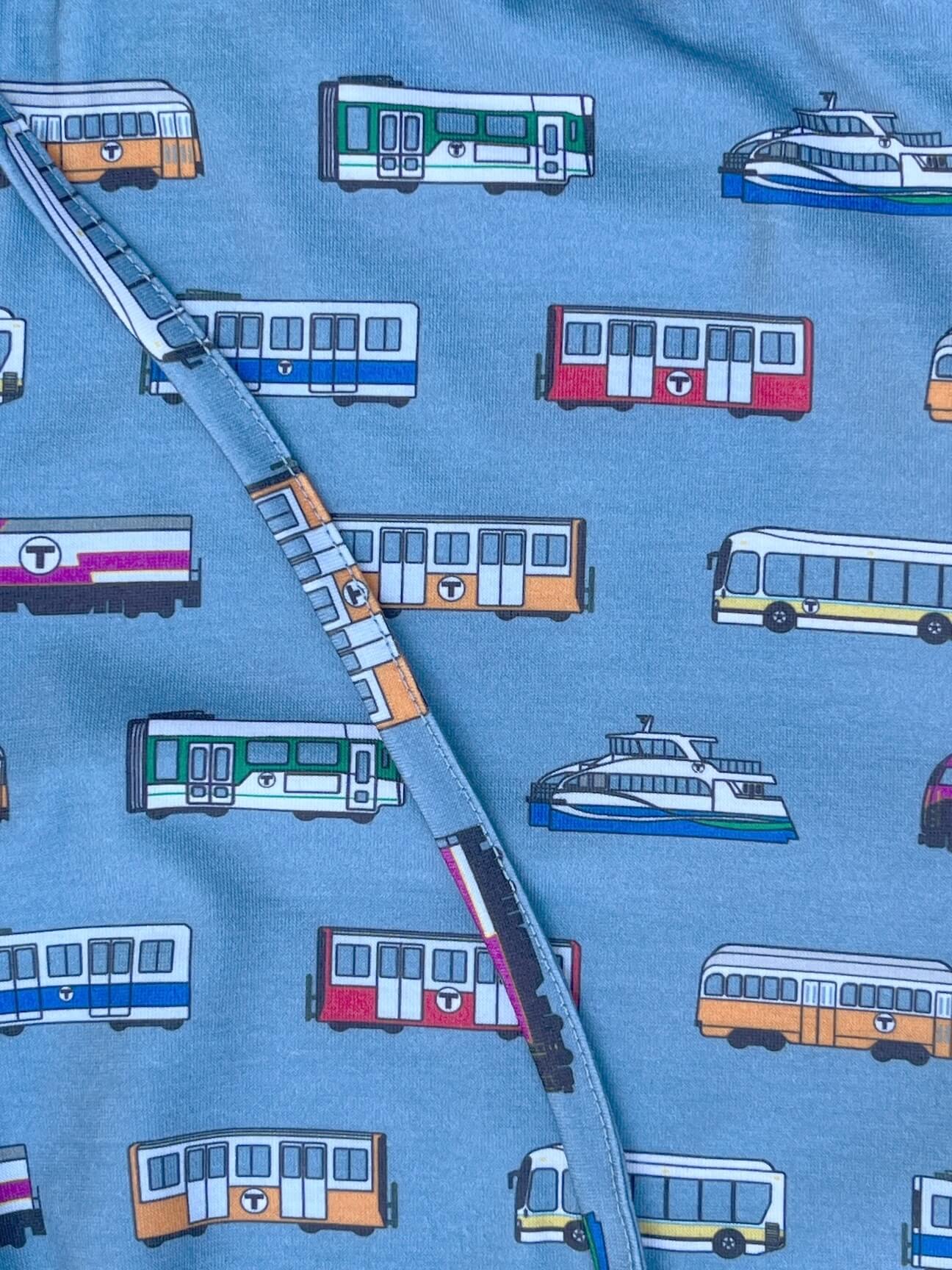 A close-up of blue pajama pants with a Boston MBTA vehicle pattern
