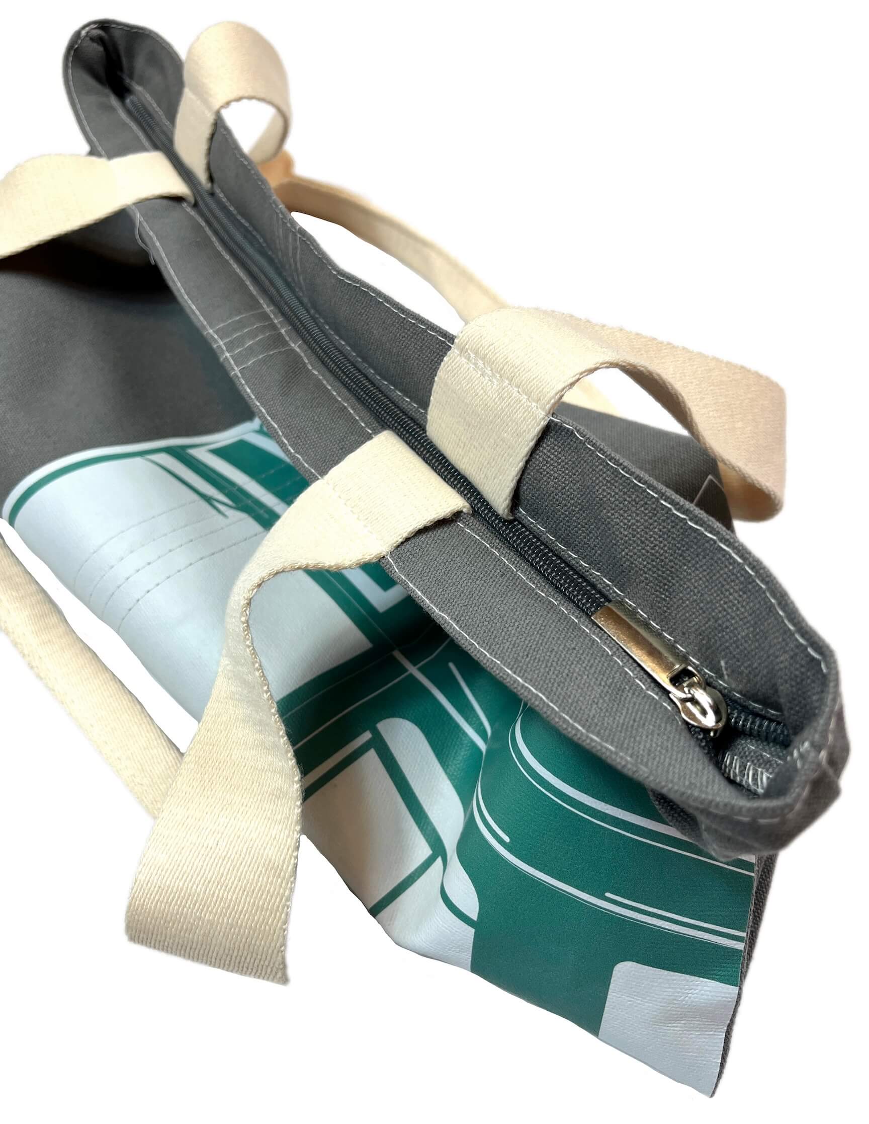 Charcoal grey canvas tote bag with large green and white Boston MBTA Green Line Trolley graphic and zipper closure