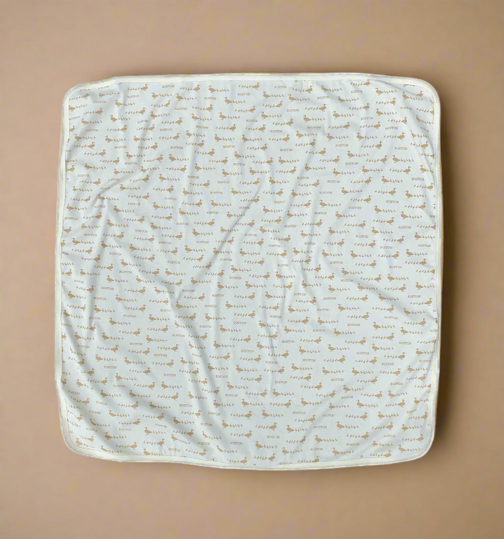 Soft cotton baby swaddle blanket with ivory and golden-brown Boston ducklings pattern