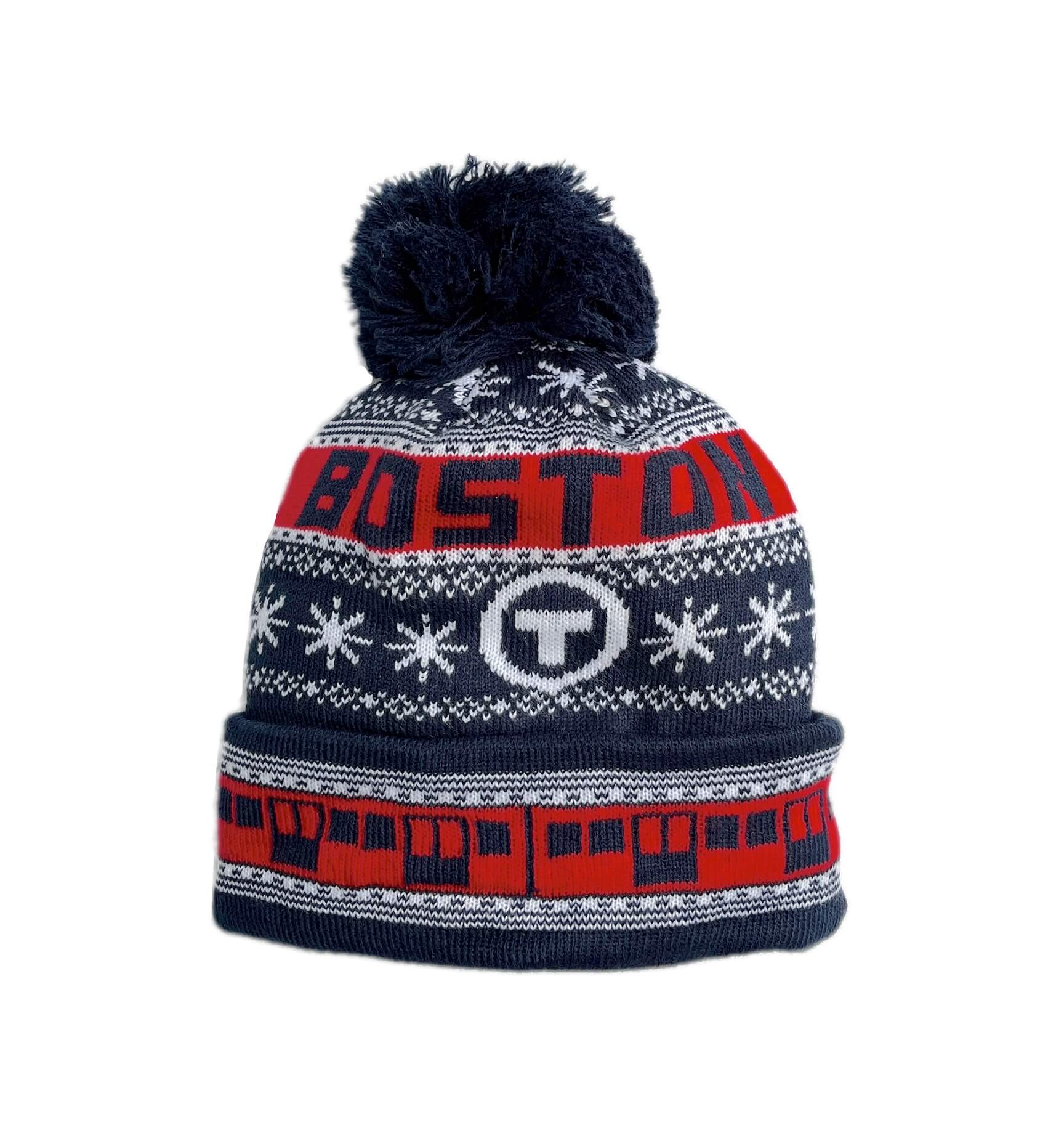 A navy blue kids knit beanie with a matching pom-pom, featuring the MBTA Red Line Train and holiday patterns, snowflakes, and the word 'BOSTON' across the top.