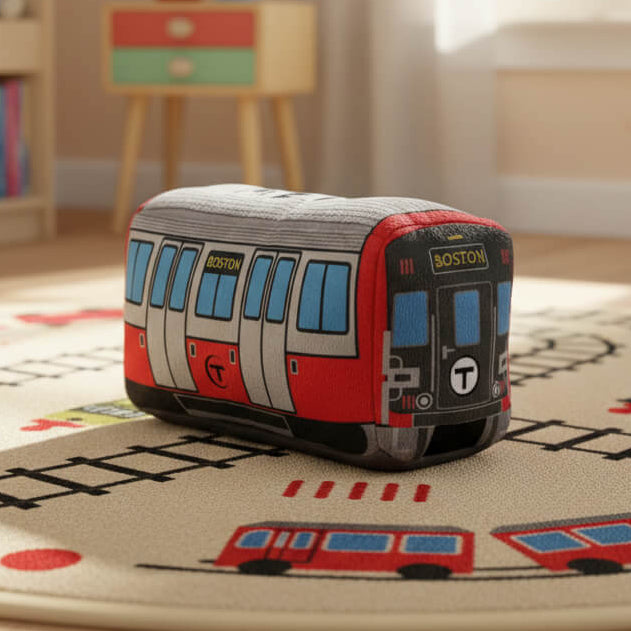 Boston MBTA Red Line subway train plush toy on a play mat within a children's bedroom.