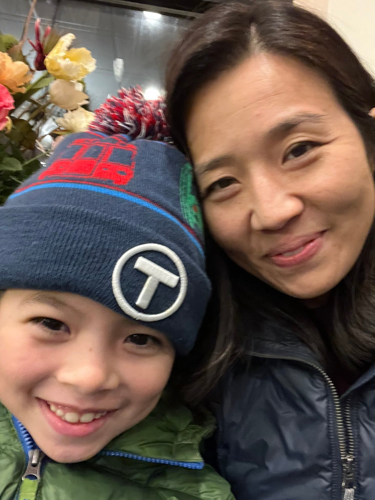 Mayor Michelle Wu and son wearing MBTA kids pom pom winter hat
