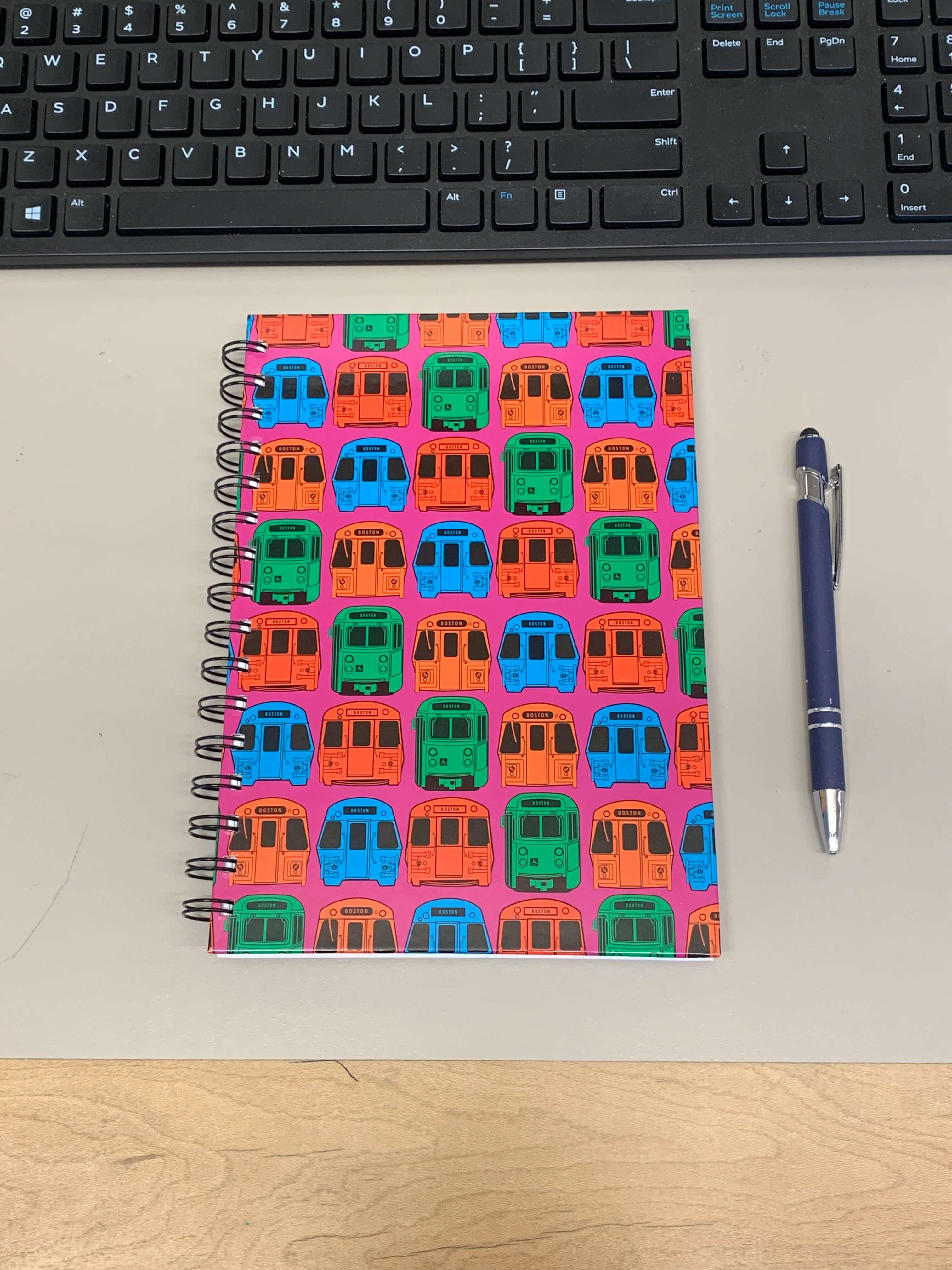 pink mbta train pattern souvenir notebook on desk